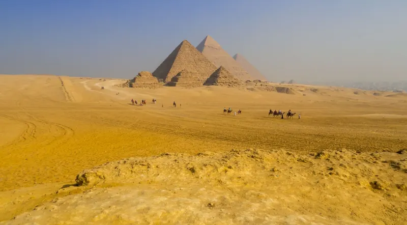 Panorama of the Giza Plateau with all three pyramids and camel riders
